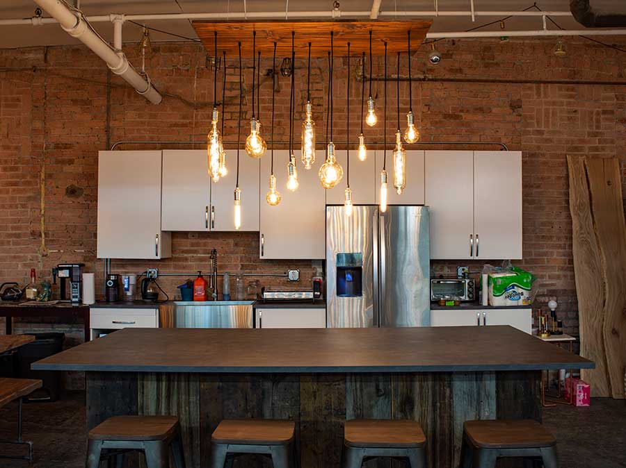 Industrial Kitchen with Large Wood Chandelier and Oversized Light Bulbs