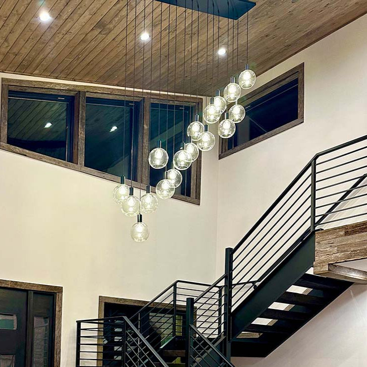 cascading linear chandelier with glass globes in stairway