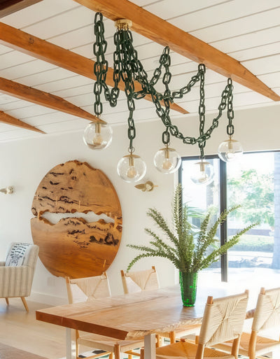 oversized chunky chain evergreen with brass globe swag chandelier over wooden modern dining table