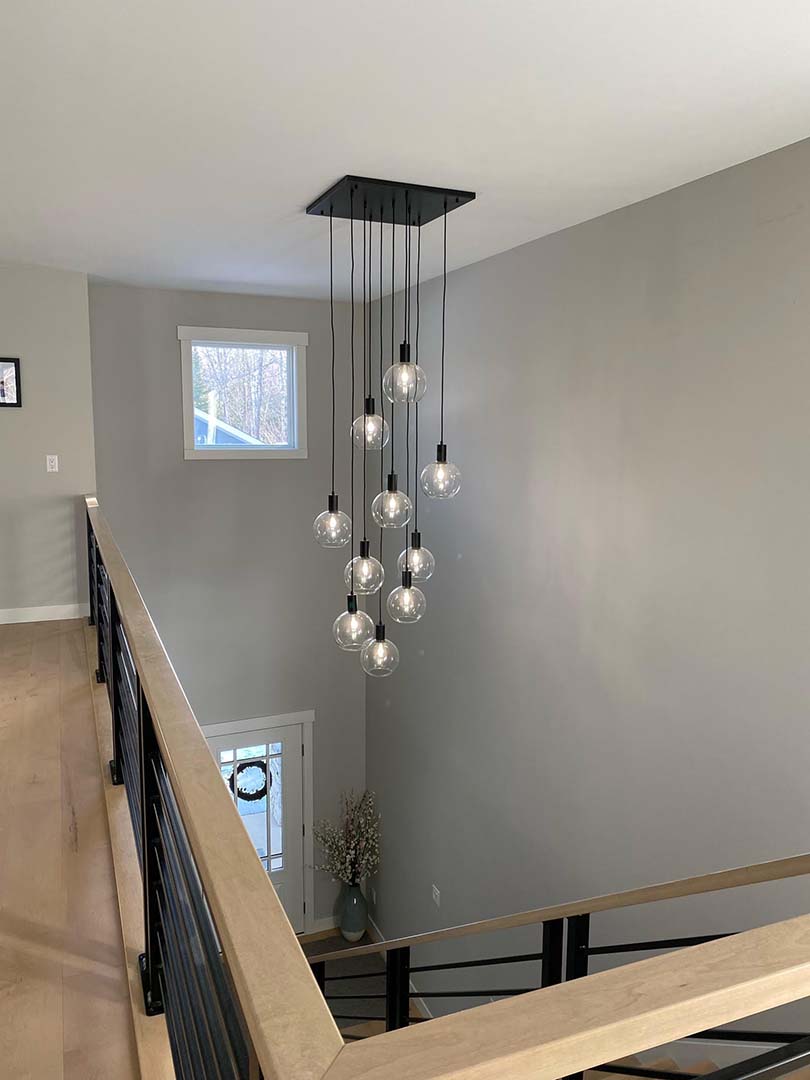 modern square pendant chandelier with glass shades in stairway foyer