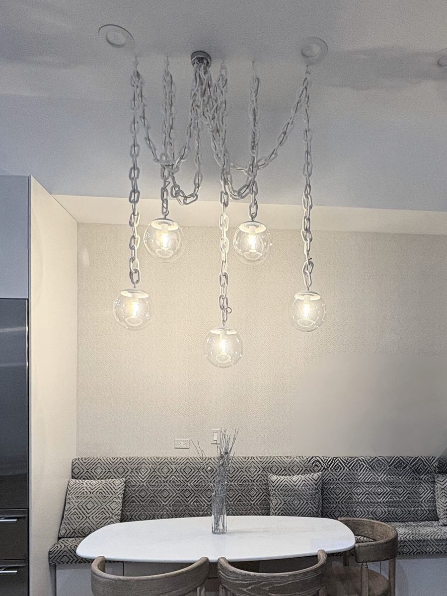 white chandelier over small dining table with bench